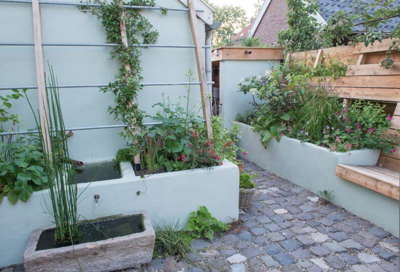 Door in de kleine stadstuin met schuine lijnen te werken komt er meer lucht en ruimte in het Buitenleven tuinontwerp van Emiel Versluis